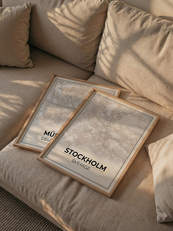 Framed city posters resting on a cozy beige sofa