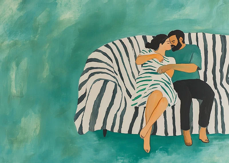 A couple rests together on a striped sofa, filled with harmony-12
