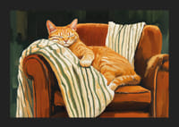 En katt sover fridfullt i en fåtölj med randig filt-5