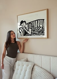She rests dreamily on a striped sofa in monochrome elegance.-8