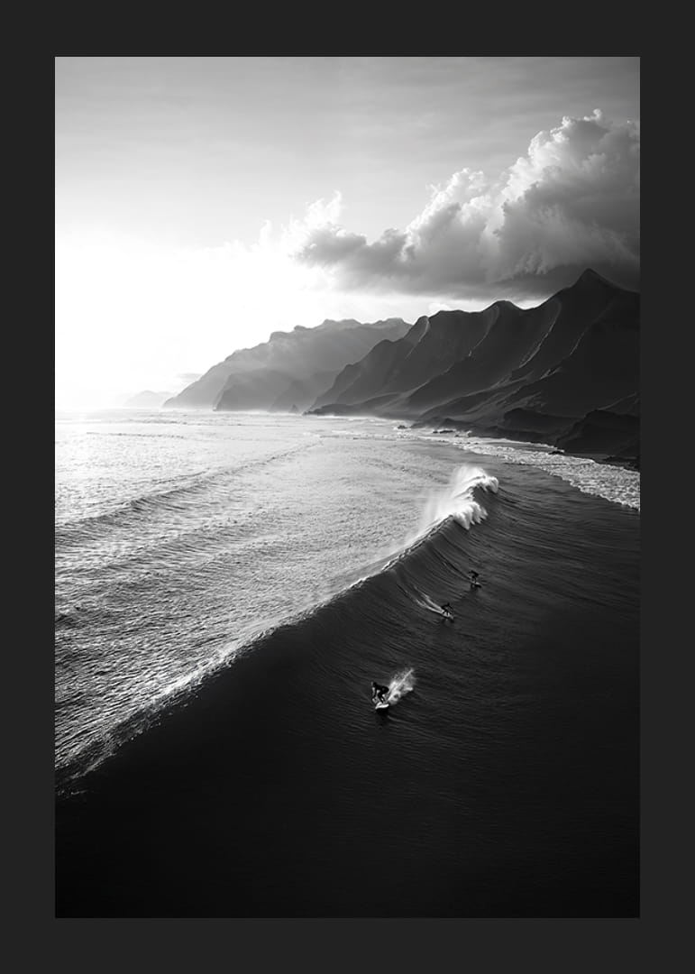 Black and white poster with surfers riding powerful waves on a dramatic coastline-12