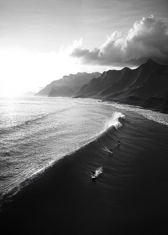 Black and white poster with surfers riding powerful waves on a dramatic coastline-12