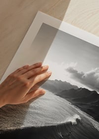 Black and white poster with surfers riding powerful waves on a dramatic coastline-9