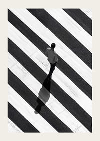 A man walks across a striped crosswalk in black and white-3