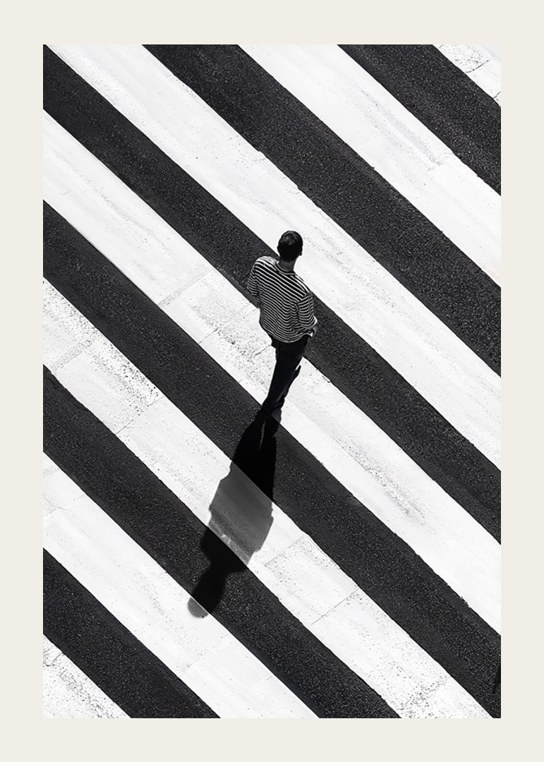 A man walks across a striped crosswalk in black and white-12
