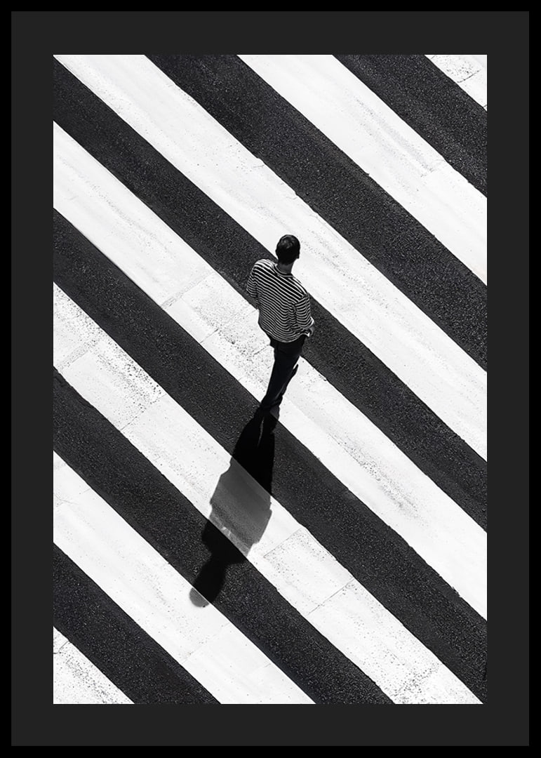 A man walks across a striped crosswalk in black and white-12