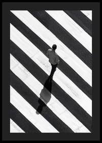 En man promenerar över ett randigt övergångsställe i svartvitt-4