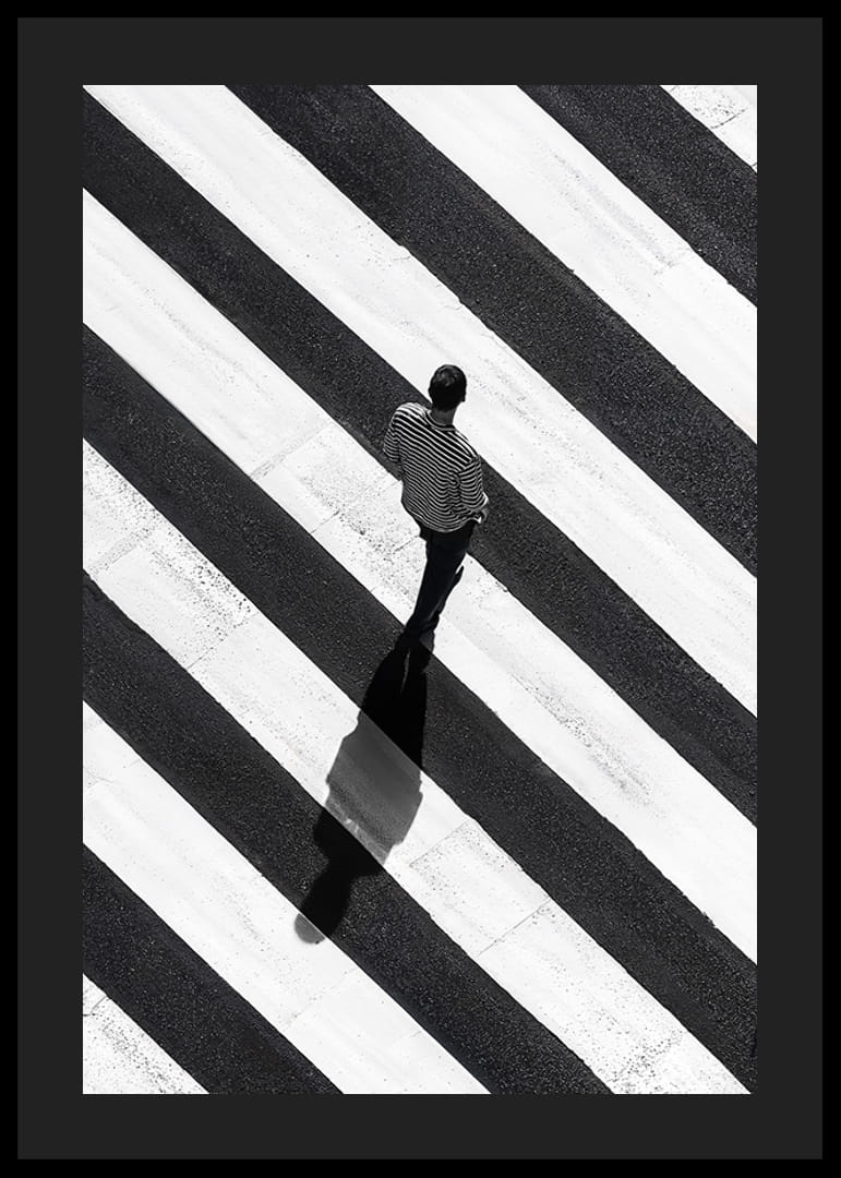 En man promenerar över ett randigt övergångsställe i svartvitt-12