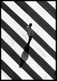 A man walks across a striped crosswalk in black and white-6