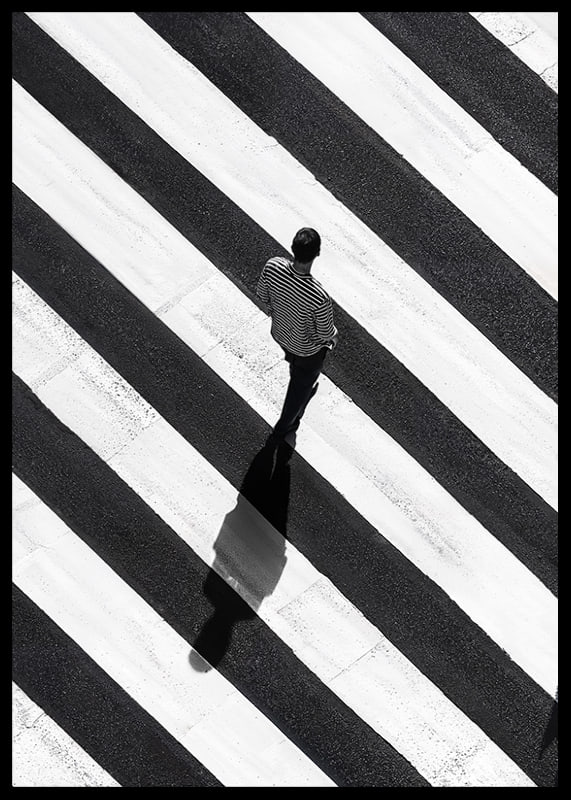 A man walks across a striped crosswalk in black and white-12