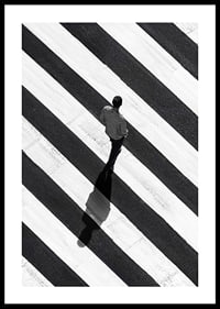 A man walks across a striped crosswalk in black and white-0