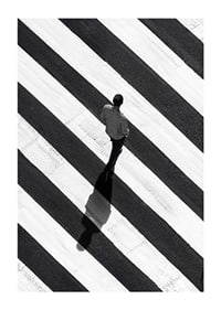 A man walks across a striped crosswalk in black and white-1