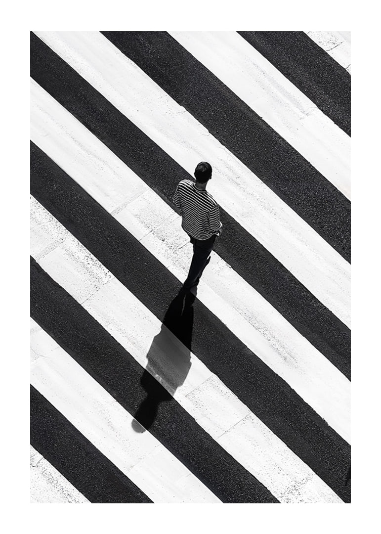 A man walks across a striped crosswalk in black and white-12