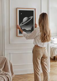 A surreal black and white scene where Saturn rises powerfully over an earthly landscape.-4
