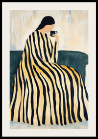 En kvinde i en stribet kjole nyder en kop te på en sofa.-2