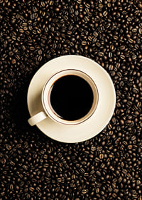 En perfekt vit kopp omgiven av mörka kaffebönor.-7
