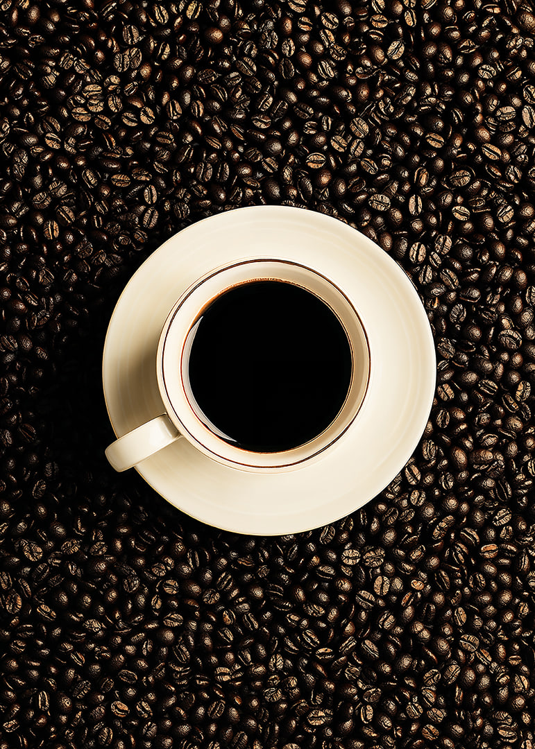 En perfekt vit kopp omgiven av mörka kaffebönor.-12