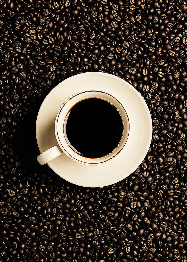 O ceașcă albă perfectă înconjurată de boabe de cafea închise la culoare.-12