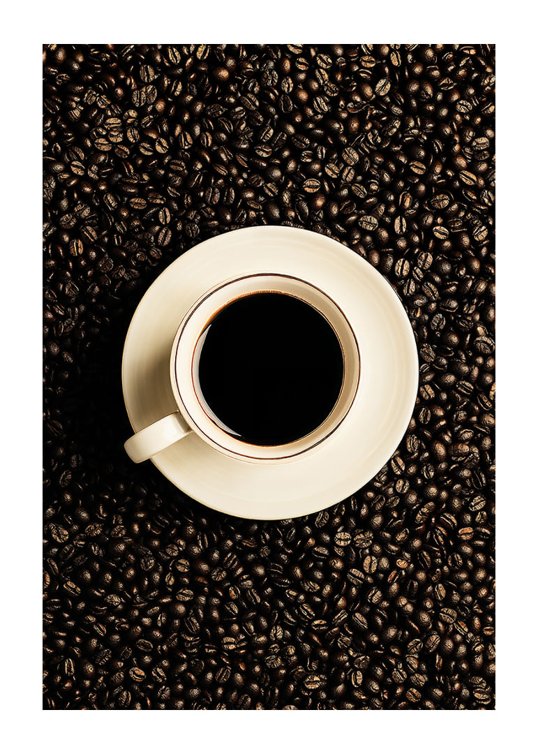 O ceașcă albă perfectă înconjurată de boabe de cafea închise la culoare.-12