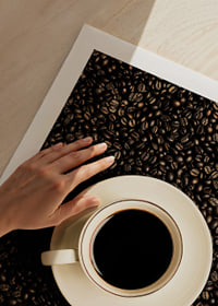 En perfekt vit kopp omgiven av mörka kaffebönor.-9