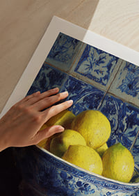 Fresh lemons in a blue and white bowl against tiled walls.-9