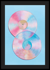 Twee glinsterende vinylplaten in pasteltinten tegen een blauwe achtergrond.-4