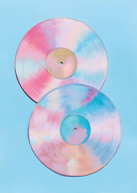 Deux disques vinyles scintillants aux tons pastel sur fond bleu.-3