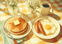A sunny breakfast of pancakes and eggs in a warm atmosphere.-7