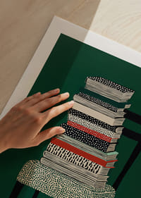 Ein bunter Bücherstapel auf einem Stuhl vor grünem Hintergrund.-5