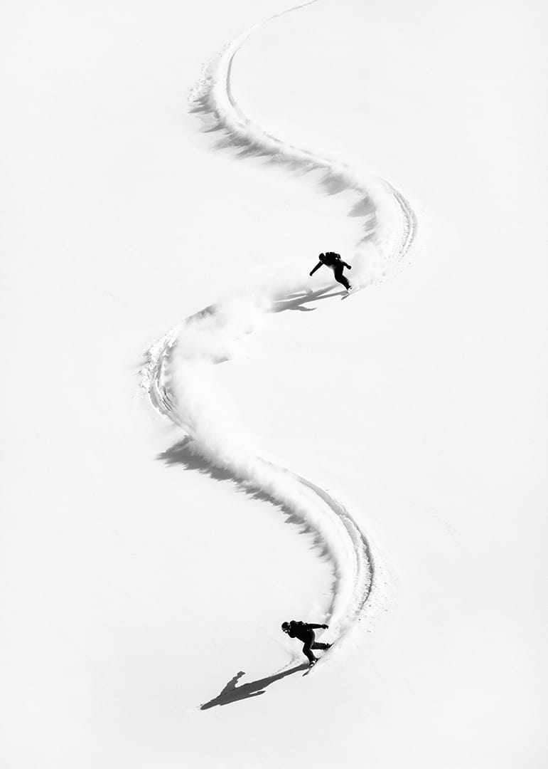 Two skiers meander through the white landscape of snow.-12