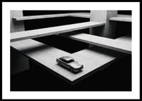 Een klassieke Aston Martin DB5 zweeft boven het moderne betonnen landschap.-0