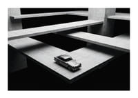 Een klassieke Aston Martin DB5 zweeft boven het moderne betonnen landschap.-1