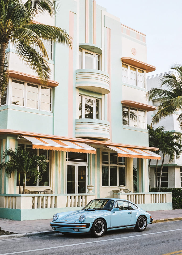 Een iconische Porsche 911 voor een pastelkleurig gebouw wekt nostalgische gevoelens op.-12