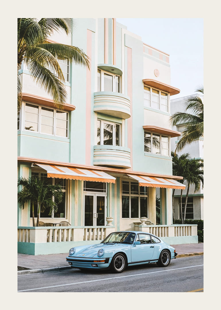 An iconic Porsche 911 in front of a pastel building creates nostalgia.-12