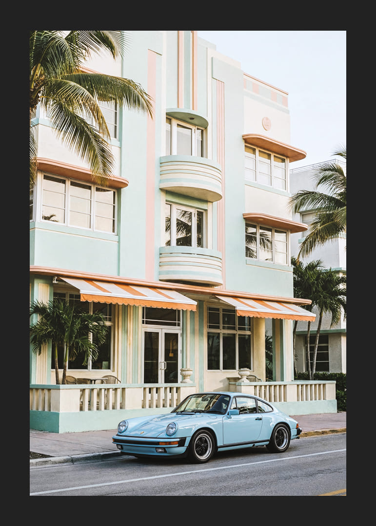 An iconic Porsche 911 in front of a pastel building creates nostalgia.-12