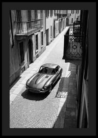 En klassisk Jaguar E-Type majestätiskt på en solbelyst stenlagd gata.-4