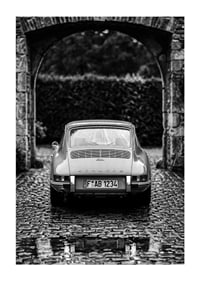 A classic Porsche 911 in a rainy landscape gives a nostalgic feeling.-1