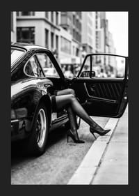 Elegant legs extend from a Porsche 911 in an urban setting.-5