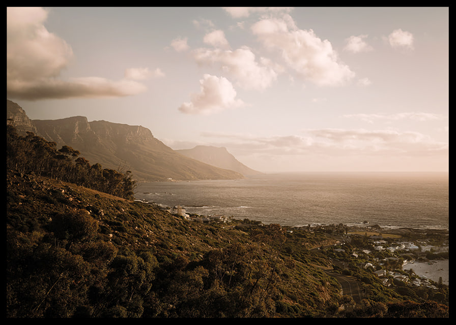 Soft clouds float over a peaceful coastline at sunset.-12