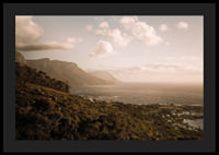 Soft clouds float over a peaceful coastline at sunset.-0