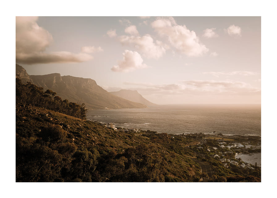 Soft clouds float over a peaceful coastline at sunset.-12