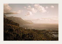 Soft clouds float over a peaceful coastline at sunset.-5