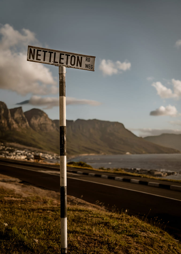 Un panneau routier indiquant la direction des montagnes et de la mer dans la lueur du coucher de soleil.-12