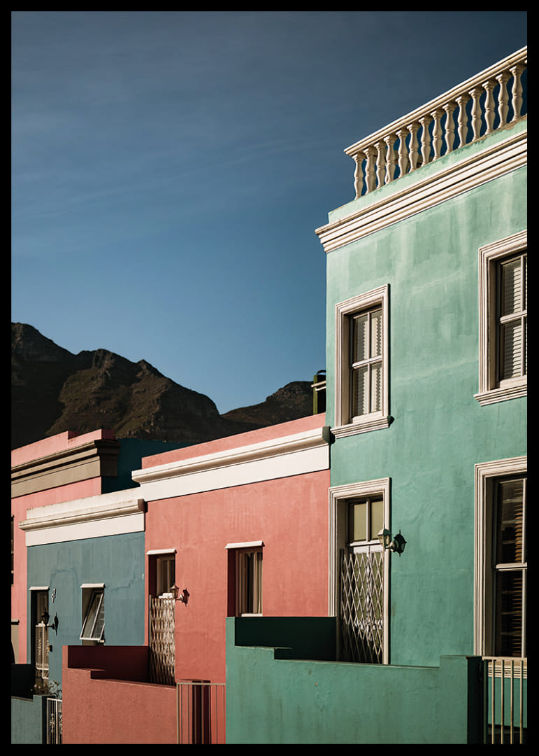 Des maisons colorées contrastent fortement avec la silhouette des montagnes.-12