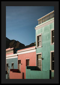 Des maisons colorées contrastent fortement avec la silhouette des montagnes.-0