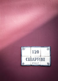 Élégant mur violet orné d'un charmant panneau indiquant le nom de la rue.-3