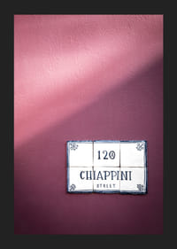 Élégant mur violet orné d'un charmant panneau indiquant le nom de la rue.-1