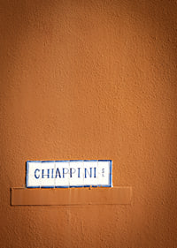 Warm terracotta-colored wall element with stylish street name.-7