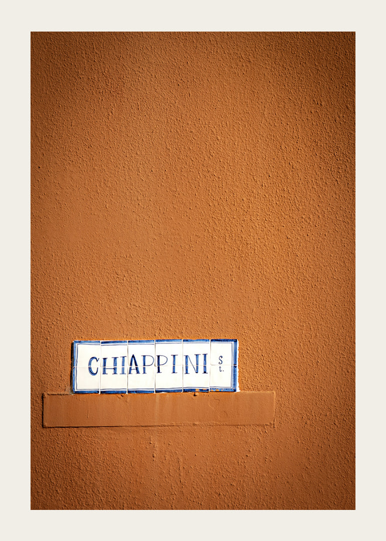 Warm terracotta-colored wall element with stylish street name.-12