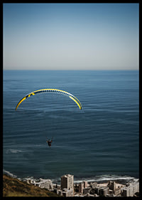 A paraglider soars majestically over the sea and the city.-6